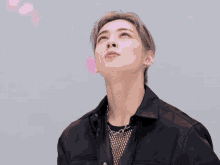 a close up of a man with pink petals falling on his face