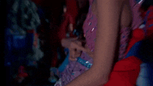 a woman in a purple and blue dress is pointing at her waist .