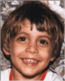 a young boy with a missing tooth smiles for a picture