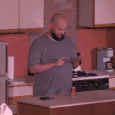 a man standing in a kitchen with a can of soda on the counter