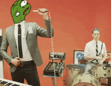 a man in a suit and tie is holding a microphone with a green face on it
