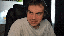 a man wearing headphones is sitting in front of a computer screen