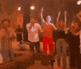 a group of people are dancing together in a living room .