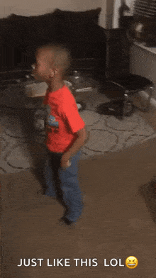 a young boy is dancing in a living room with the words just like this lol below him .
