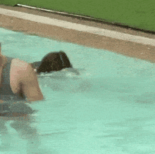 a dolphin is swimming in a swimming pool and splashing water