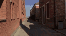 a narrow alleyway between two brick buildings with shadows on the ground