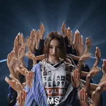 a woman wearing a shirt that says ms surrounded by hands