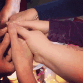 a group of people stacking their hands together