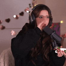 a woman wearing headphones is singing into a microphone while holding a christmas tree