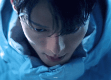 a close up of a person 's face with a blue background and a watermark that says ' ainmei '