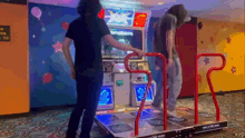 two people are playing a video game with a sign that says ' arcade ' on it