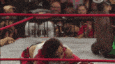 a woman with red hair is kneeling in a ring