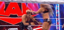 a man and a woman are wrestling in a ring on a tv show .