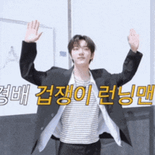 a man in a suit and striped shirt is waving his hands in front of a sign that says ' a '