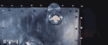 a close up of a metal surface with a coin in it