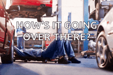 a man laying on a creeper in a garage with the words " how 's it going over there " above him