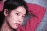 a close up of a woman wearing a red sweater holding her hair .