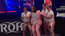 a group of men are dancing in front of a sign that says roh on it