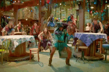 a group of people dancing in a room with tables