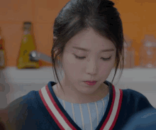a close up of a woman wearing a blue sweater