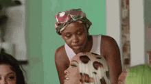 two women are standing next to each other in a room . one of the women is wearing a head scarf .