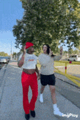 a man in a crop top is walking with a woman