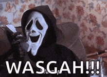 a person wearing a ghostface mask is sitting on a couch holding a cell phone .