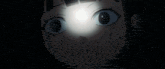 a close up of a girl 's face with a light shining on it