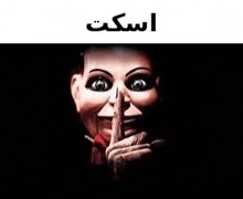 a scary puppet is holding his finger to his mouth and making a shhh sign .