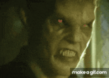a close up of a man 's face with red eyes and the words make a gif.com below him