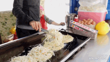 a person is cooking food on a grill next to a box of sam jin plastic wrap