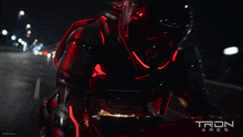a man is riding a motorcycle in a tron ares poster