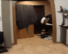 a person is standing in a hallway with a blanket on the wall .