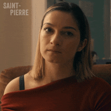 a woman sitting on a couch with saint-pierre written on the bottom right