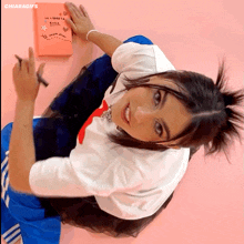 a girl is writing in a notebook that says la libreta rosa on it