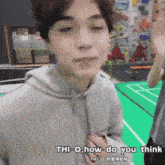 a man in a grey hoodie says " thi-o how do you think " in chinese