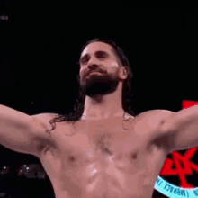 a shirtless wrestler with his arms outstretched and his mouth open