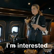 a woman is holding a martini glass and the words i 'm interested are above her