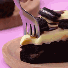 a piece of cake with a fork sticking out of it is on a wooden plate