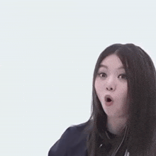 a young woman is making a surprised face with her mouth open .