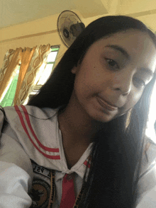 a girl in a school uniform has a lanyard around her neck that says j29