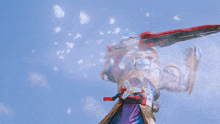 a robot is holding a red and black sword against a blue sky .