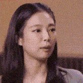 a close up of a woman 's face with long black hair .