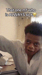 a man in a white shirt is making a funny face while sitting at a desk .