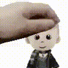 a hand is touching the head of a doll
