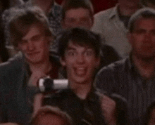 a man is making a funny face in a crowd