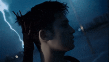 a close up of a person 's face with a lightning bolt in the background .