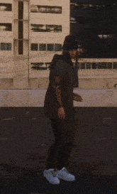 a man with a tattoo on his arm stands on a roof