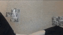 a person is laying on a bed in front of a wall with posters on it