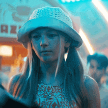 a girl wearing a hat is looking at something in front of a sign that says rex